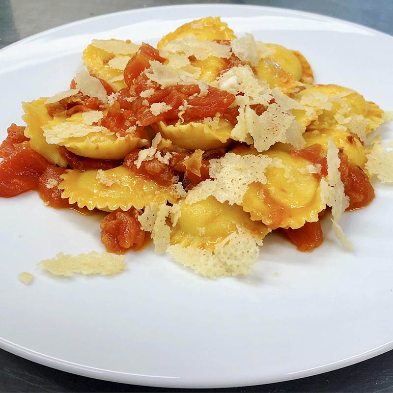 Raviolo di ricotta con pomodorino fresco e scaglie di parmigiano